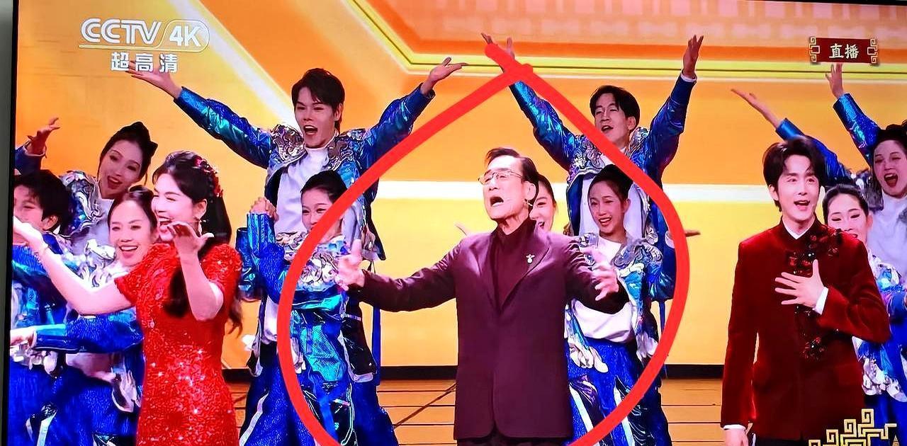 68岁影帝春晚台上僵成木头人，一下台腰杆笔直冻得哆嗦还鞠躬。你看到他那笑容了吗