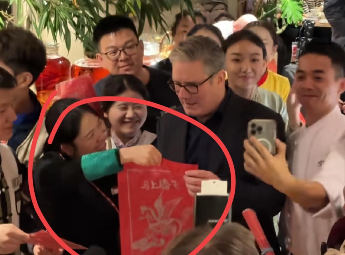 斯塔默北京吃云南菜，这位饭馆女服务员表情，太亮了！迎宾主陪，站在斯塔默身边，非常