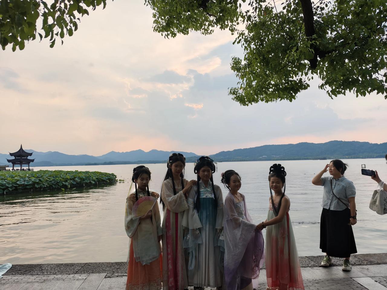 傍晚的西湖，如同一幅美丽的画卷，晚霞洒在人们的身上、湖水中的荷叶上，到处都是金光