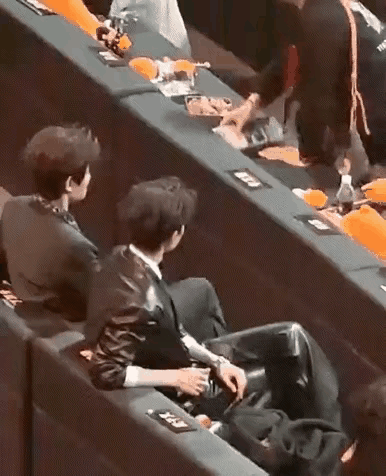 看来还真是工作人员犯的错误，她们把名牌撕下来重新粘贴的举动把后面的两个男演员逗笑