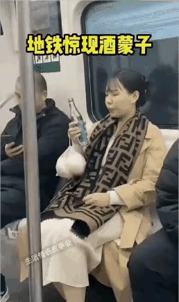 一个女人乘坐地铁，她找到了座位，坐了下来，于是从包里拿出一瓶白酒，把瓶盖打开，张
