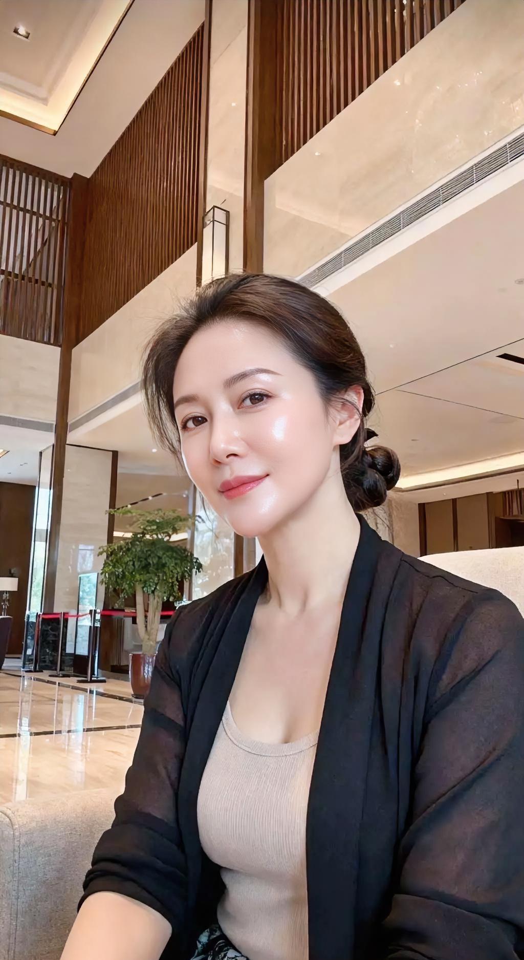 黑纱轻拢着暖，米色贴着安然。发髻挽住流年，笑意浅浅如泉。厅堂光在