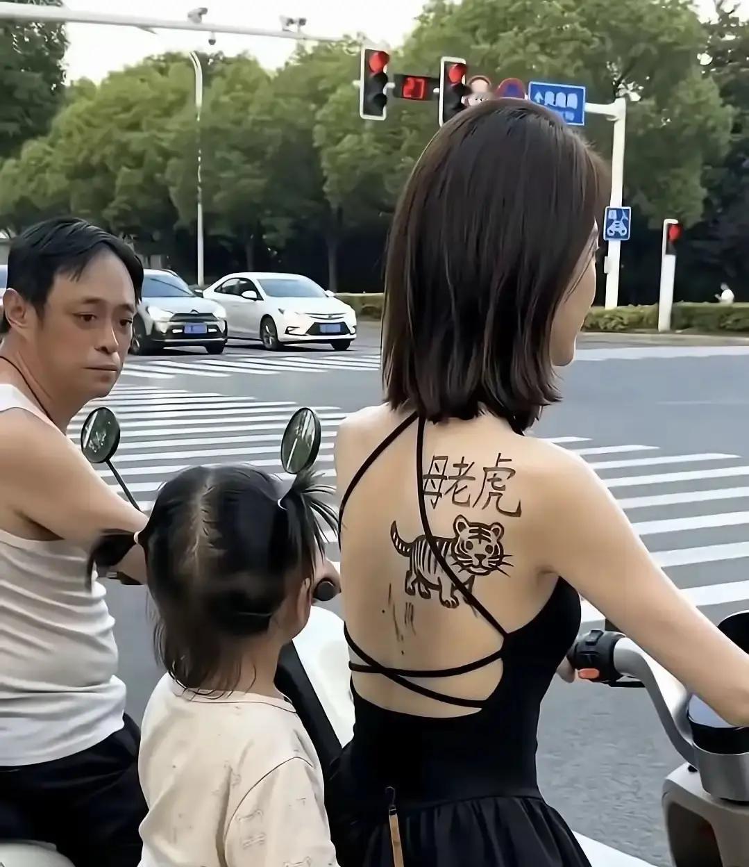 昨天在路口等红灯，旁边一辆电动车硬是把后面的司机都逗乐了骑车的妈妈穿了件黑色
