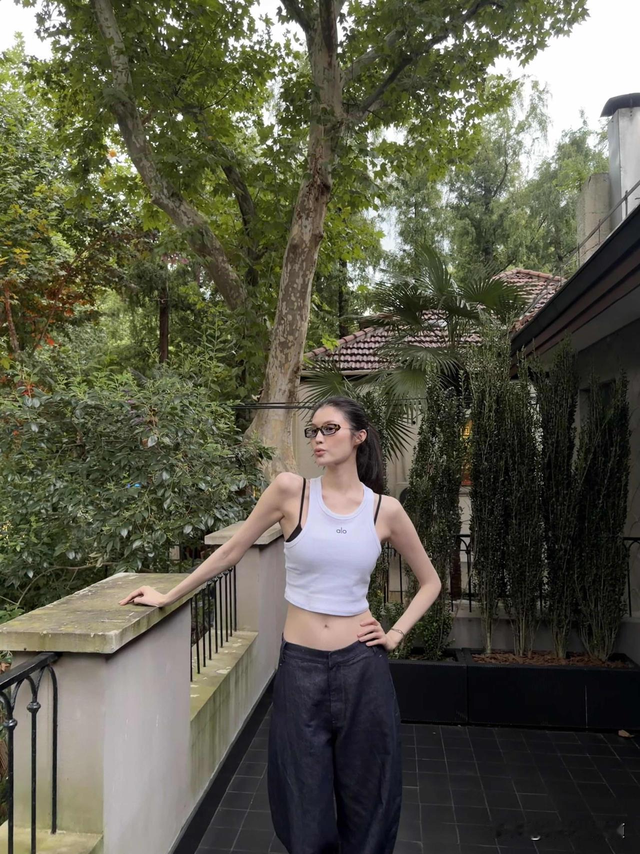 看到何穗这组庭院照，我信了：真有人披块布都像高定。基础款私服，没夸张设计，她往庭院里一站，肩颈线和比