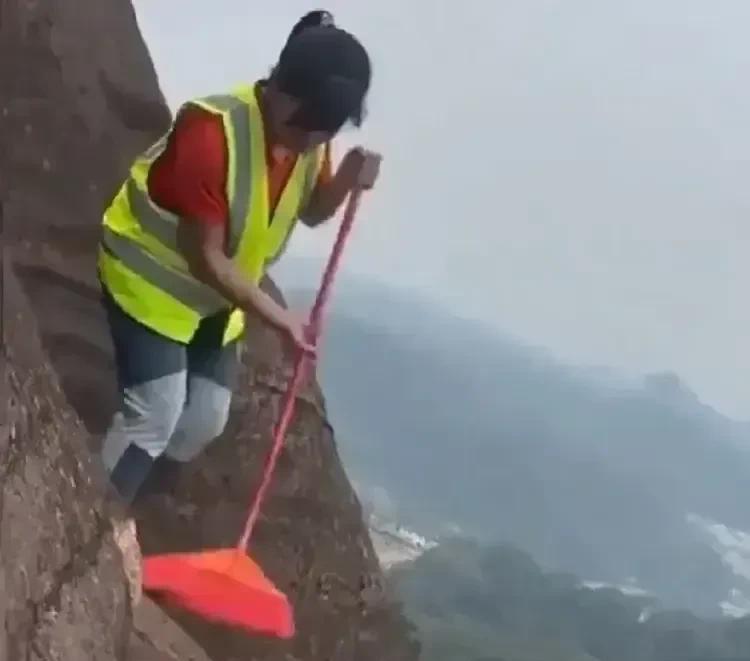 刚看到下面的图片时，认为这位大妈在悬崖峭壁上打扫卫生，没有任何防护措施，一旦掉下