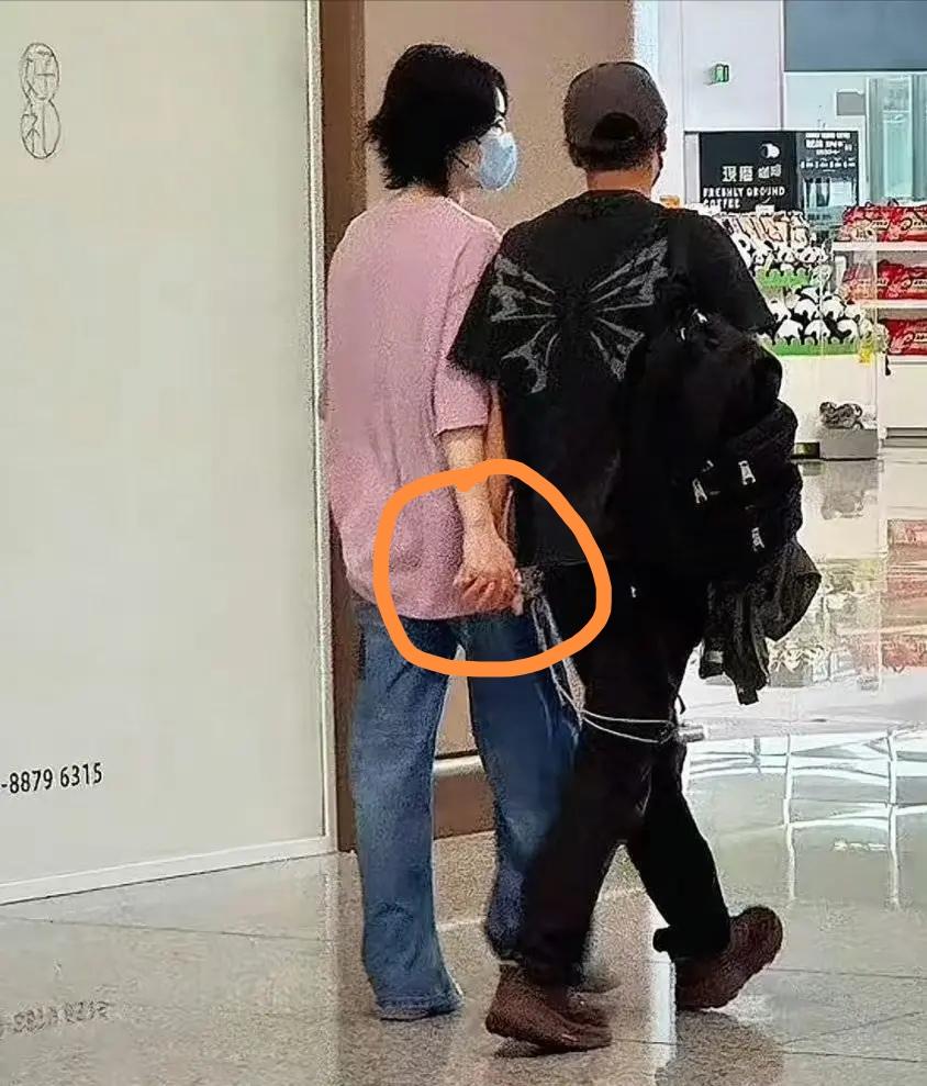 王菲与谢霆锋西安机场出发准备回北京了，王菲紫色T恤配牛仔裤，还是一派休闲与松
