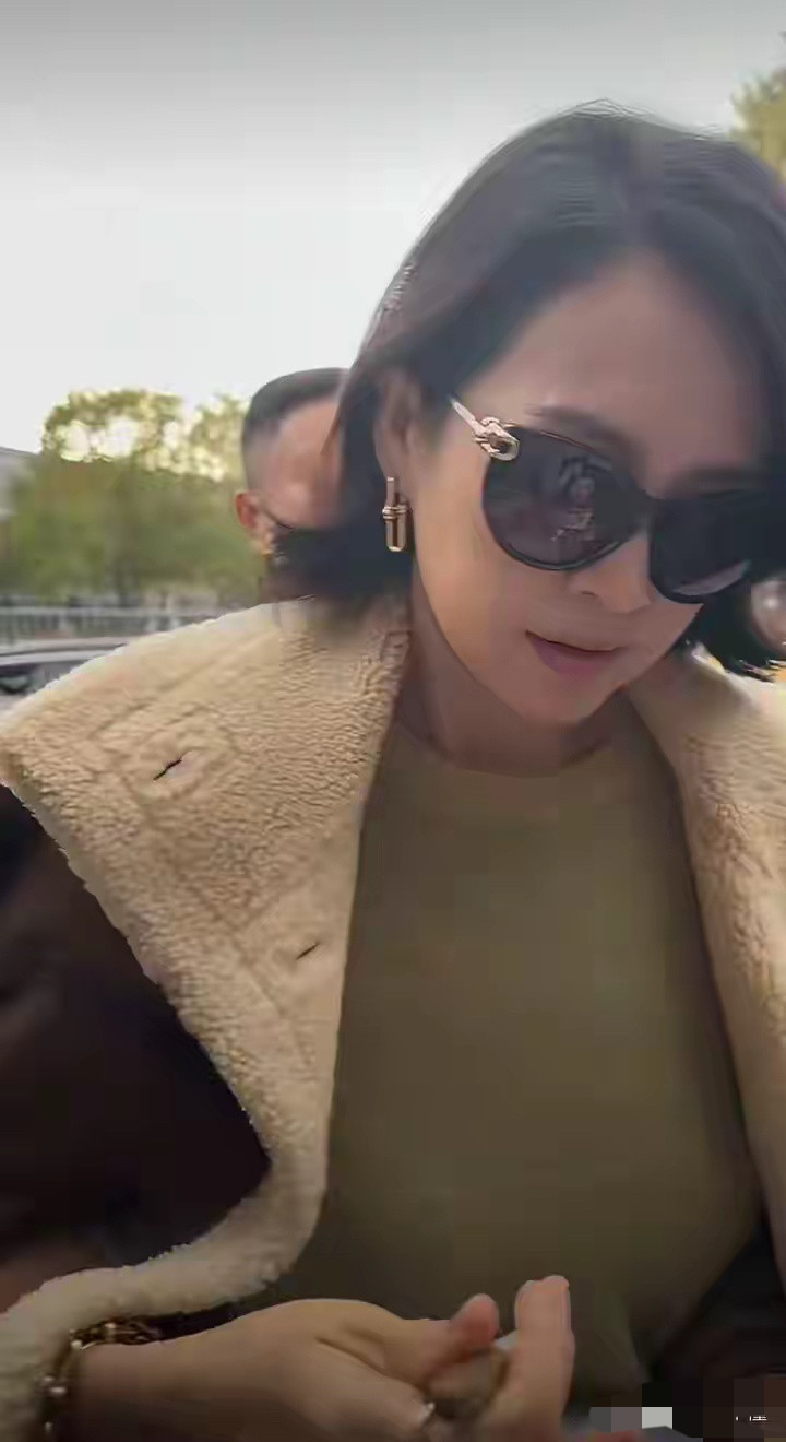 网友在国外偶遇章子怡，章子怡身边被一群外国保镖保护着，面对粉丝打招呼，章子怡特别平易近人，蹲下身子贴