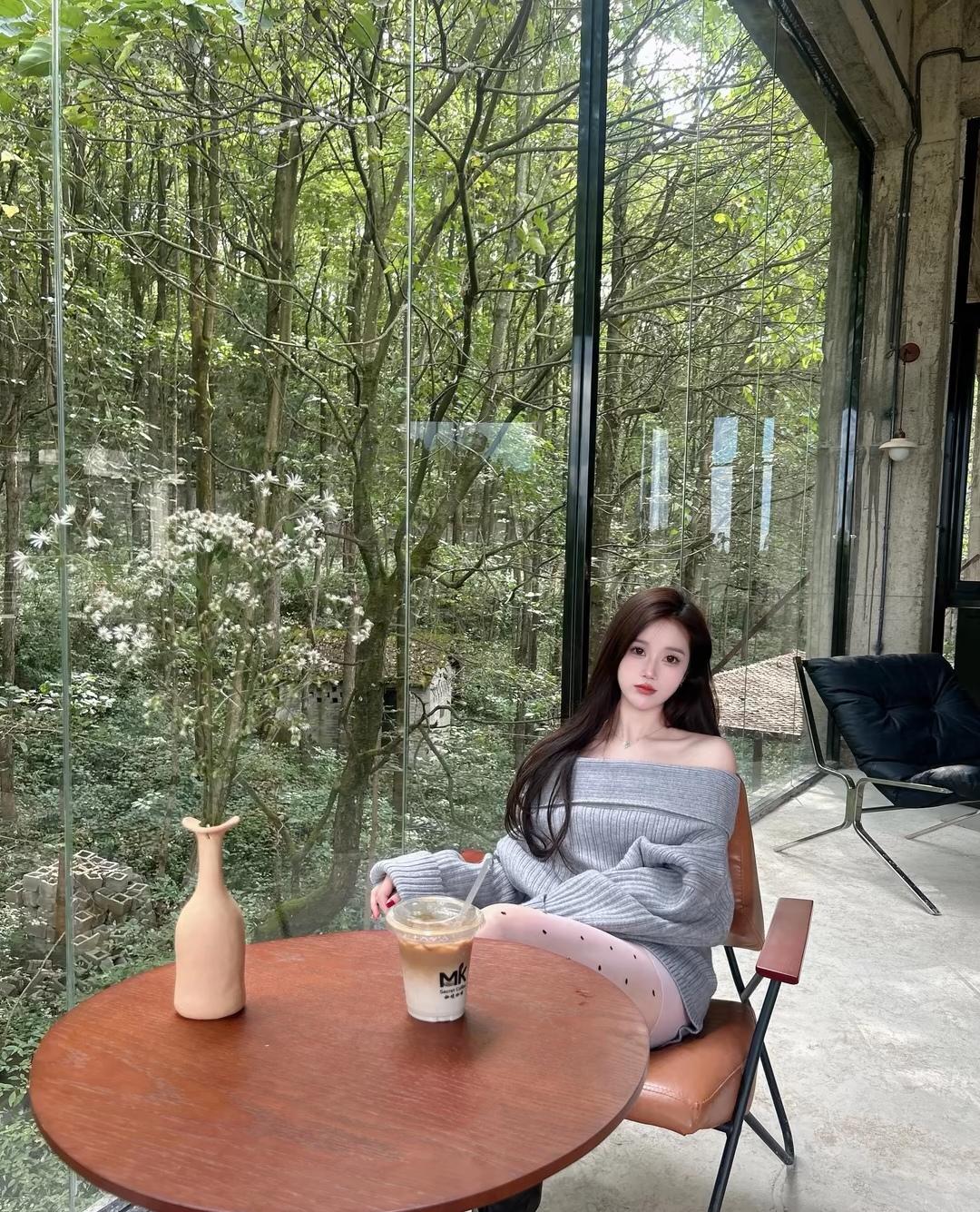 绿树掩映中，美人倚窗坐。