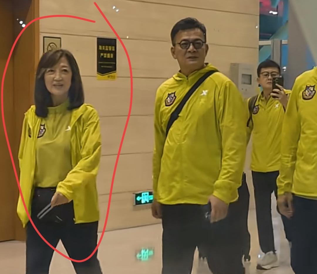 他们穿黄色衣服在走廊里走。有认识这位女士的吗？保养的真好！好年轻啊？总是笑容满面