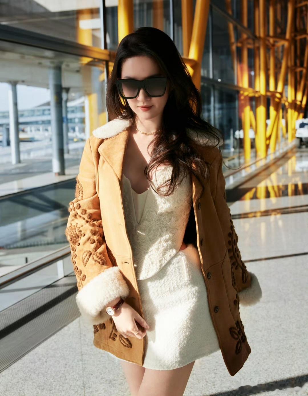 刘亦菲走的是暖调复古摩登休闲风，焦糖色麂皮绒外套，领口袖口拼接白色羊羔毛，温暖又
