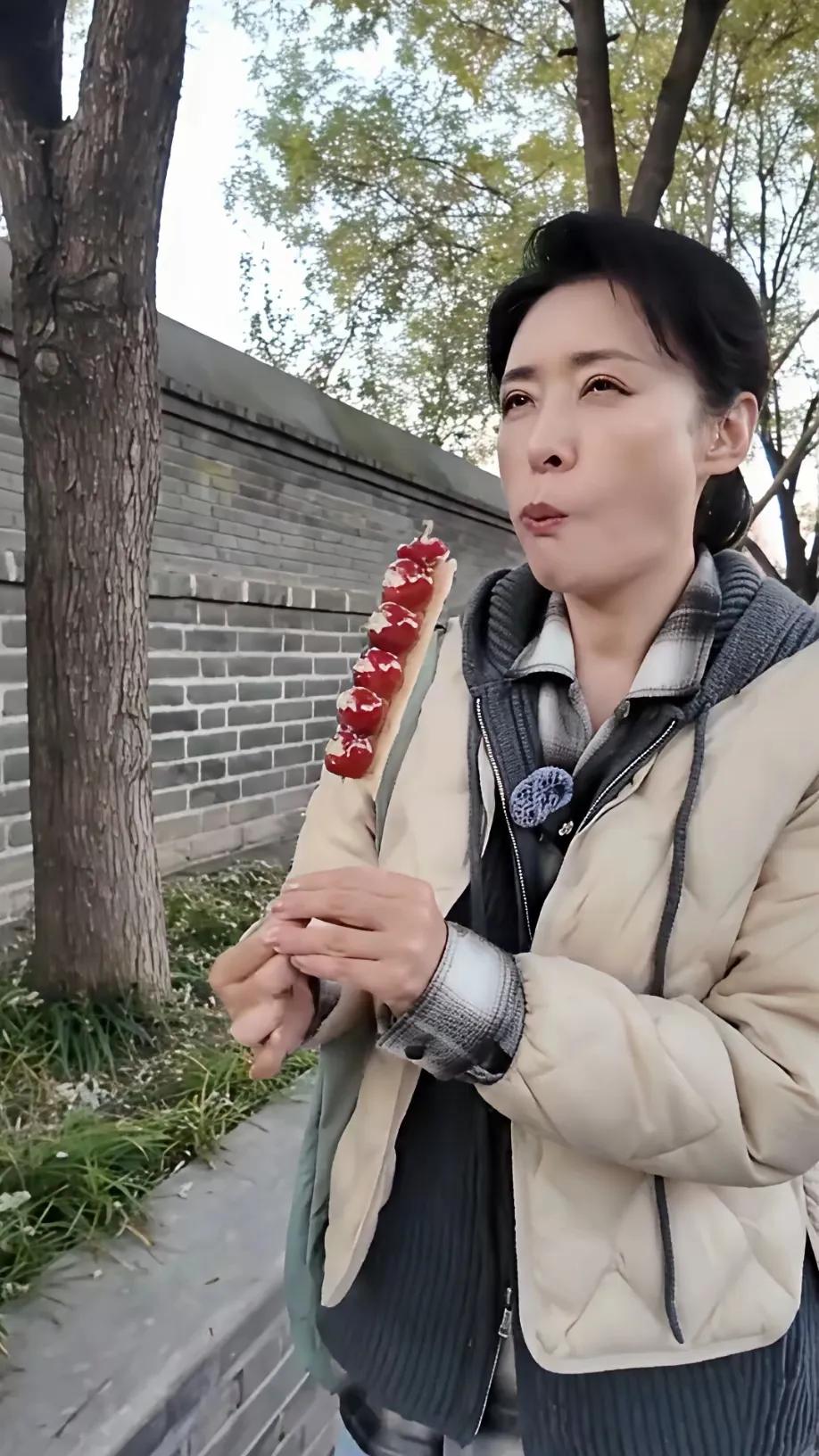 周涛连吃糖葫芦都这般优雅，瞧人家那嘴，一点都看不出是在吃东西。名人就是有高雅气质