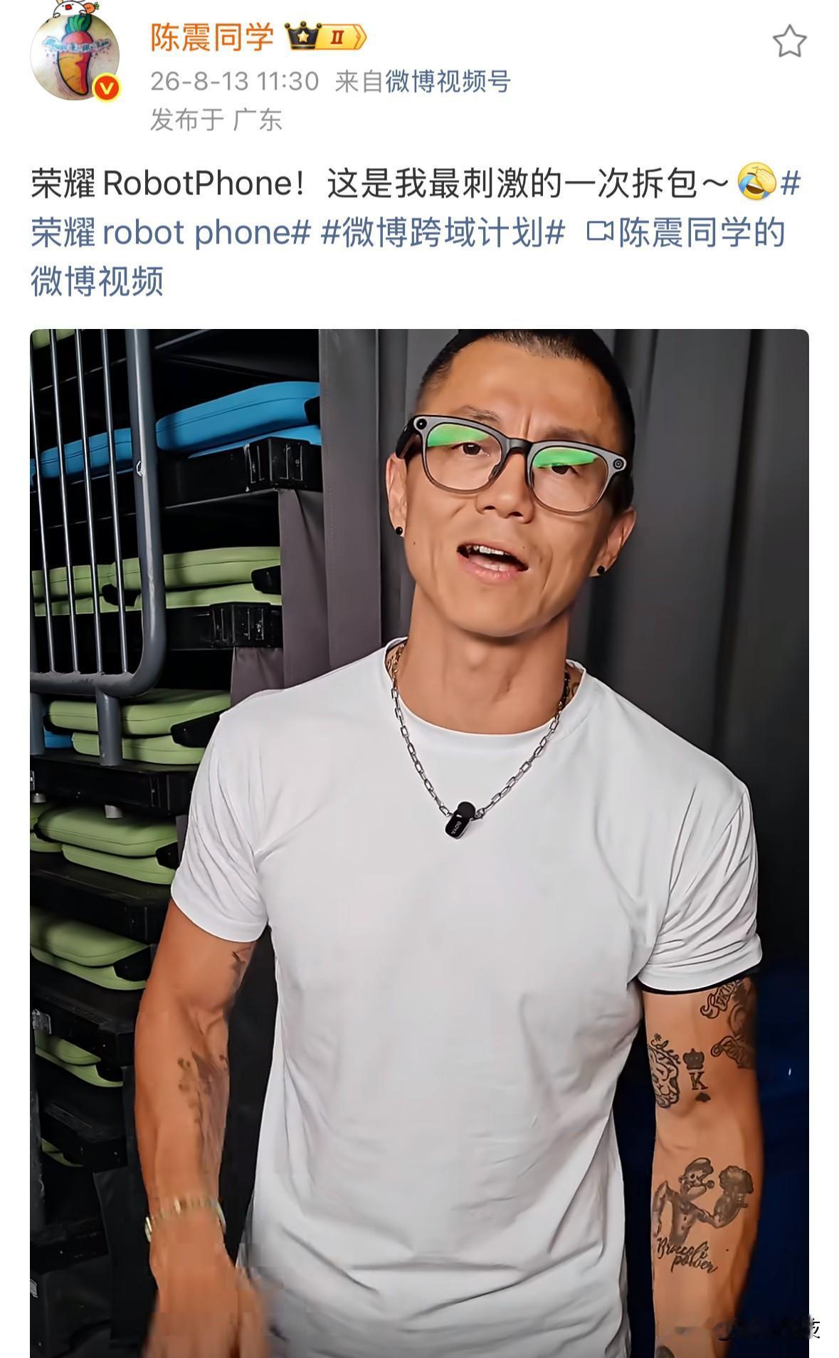 车评人陈震在荣耀现场拆包RobotPhone手机，现场多位媒体人围观，完成后依