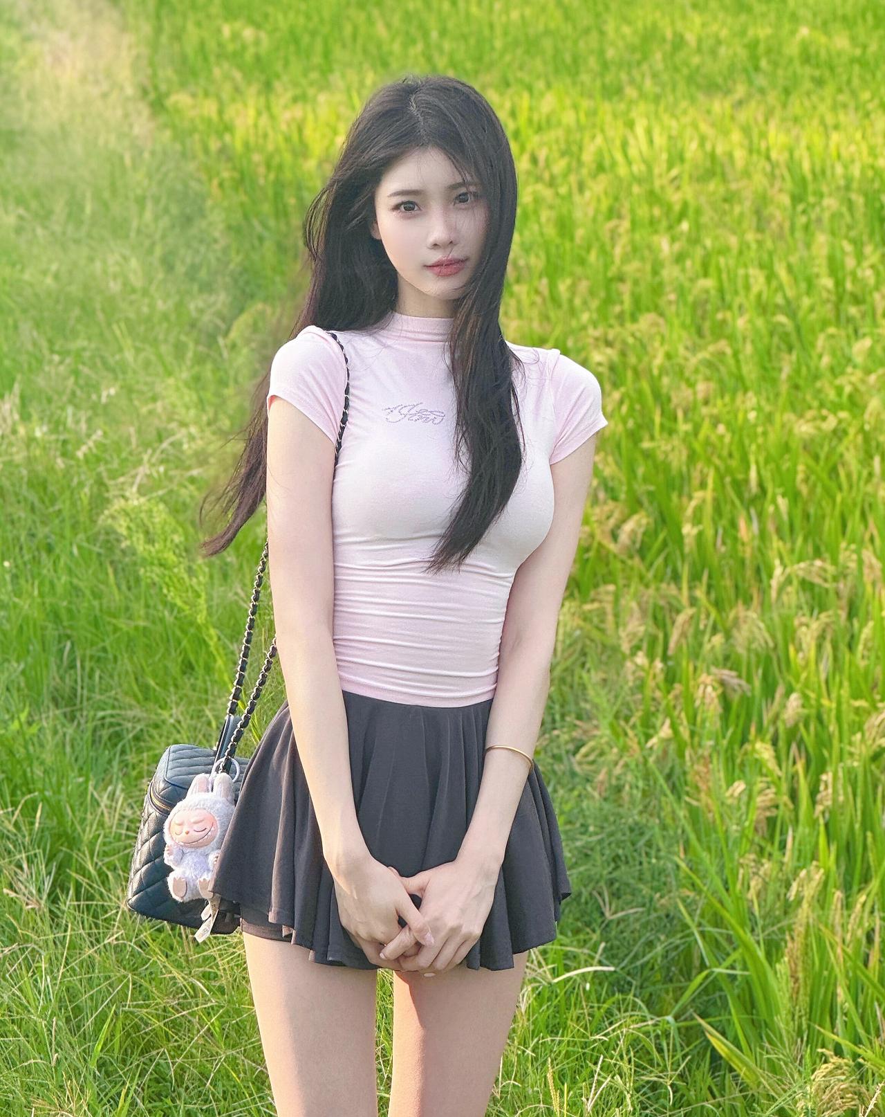 稻田的风卷着青绿的浪，粉衫黑裙揉进夏末的温柔。站在田埂的光影里，闭眼接住晚