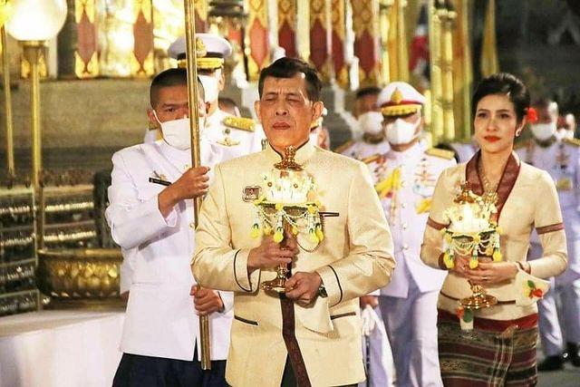 泰王和诗妮娜穿着情侣装拿着灯缓缓而行，有美娇妻陪伴在侧，泰王很享受呀。他挺会享福