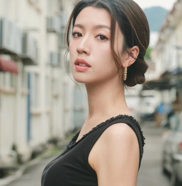 前TVB视后蔡思贝近日在西九文化区拖红色行李箱拍短片黑色小背心配短裙，大秀好身