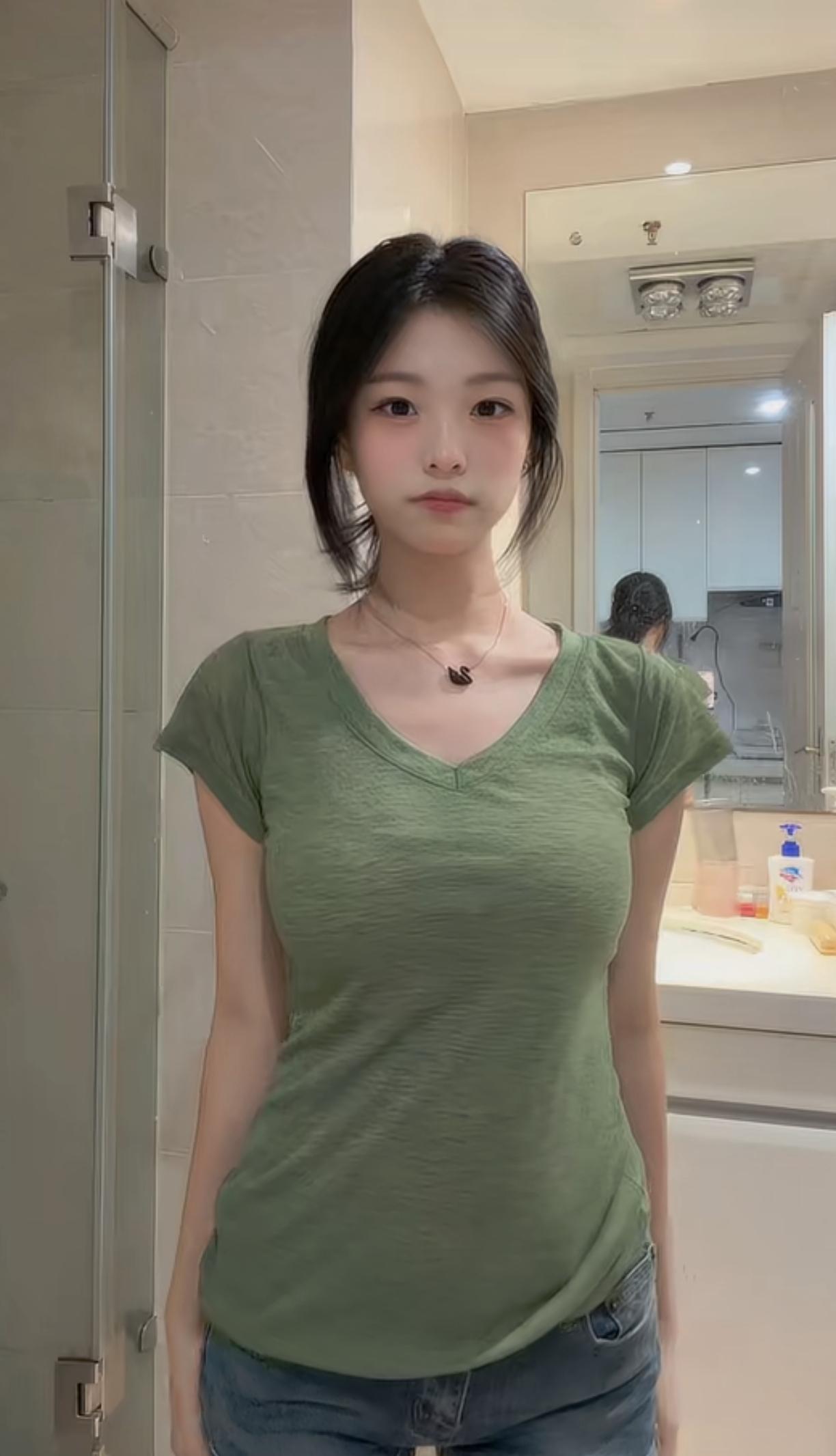 穿绿色T恤的女孩在宾馆洗澡间自拍。