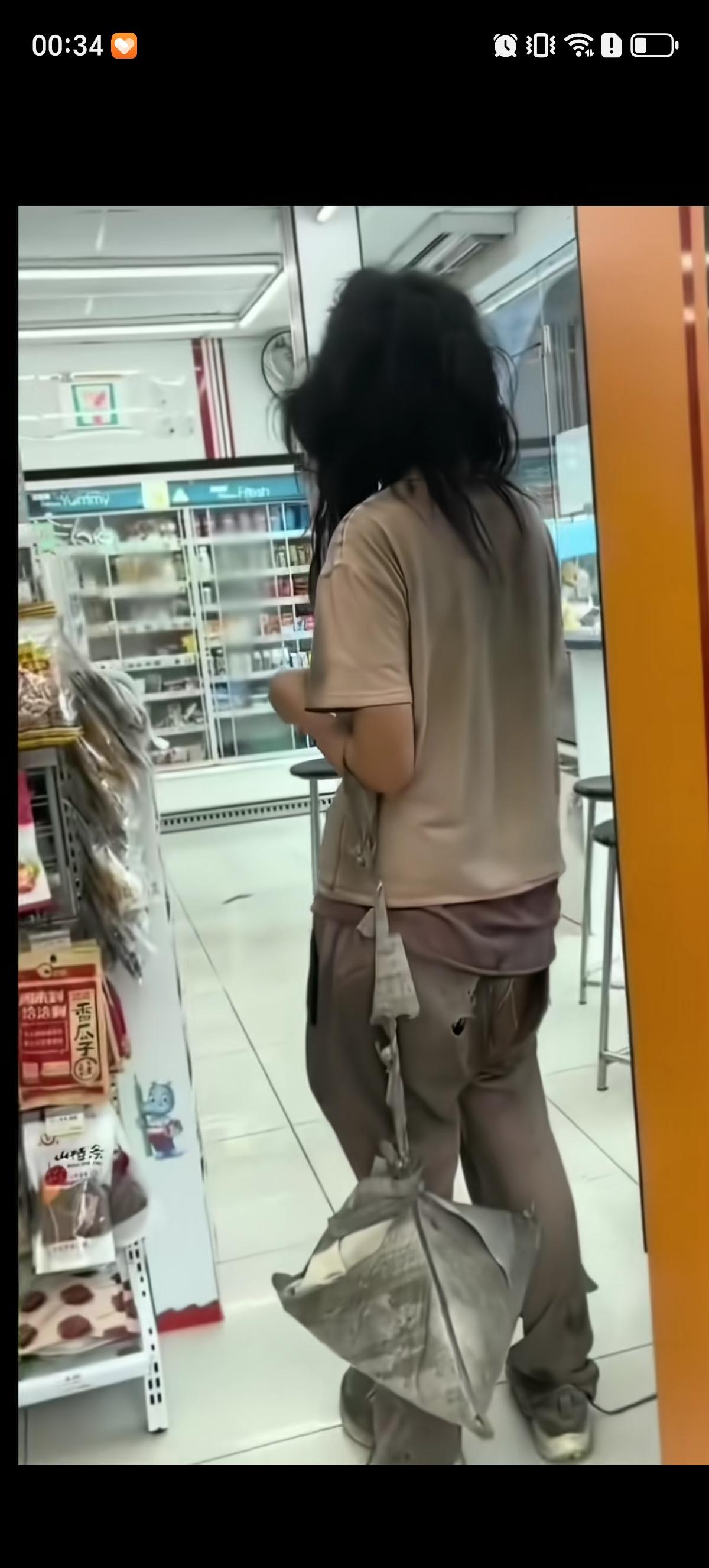 这是一位经历复杂且落魄的女子，穿着的裤子在屁股位置露出几个很明显的洞，明显遮不住
