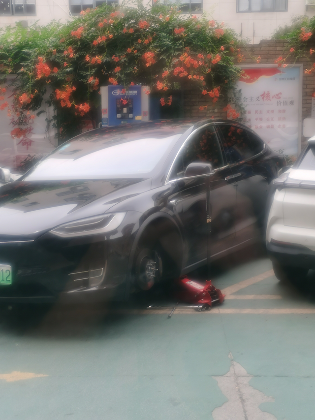 特斯拉换轮胎顶上千斤顶车门上下错位了今天在店门口看见一辆特斯拉轮胎坏了，车主