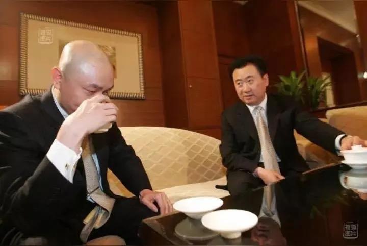 2005年的一张旧照，定格了中国商界最戏剧性的一幕。画面里，端着茶杯低头饮茶