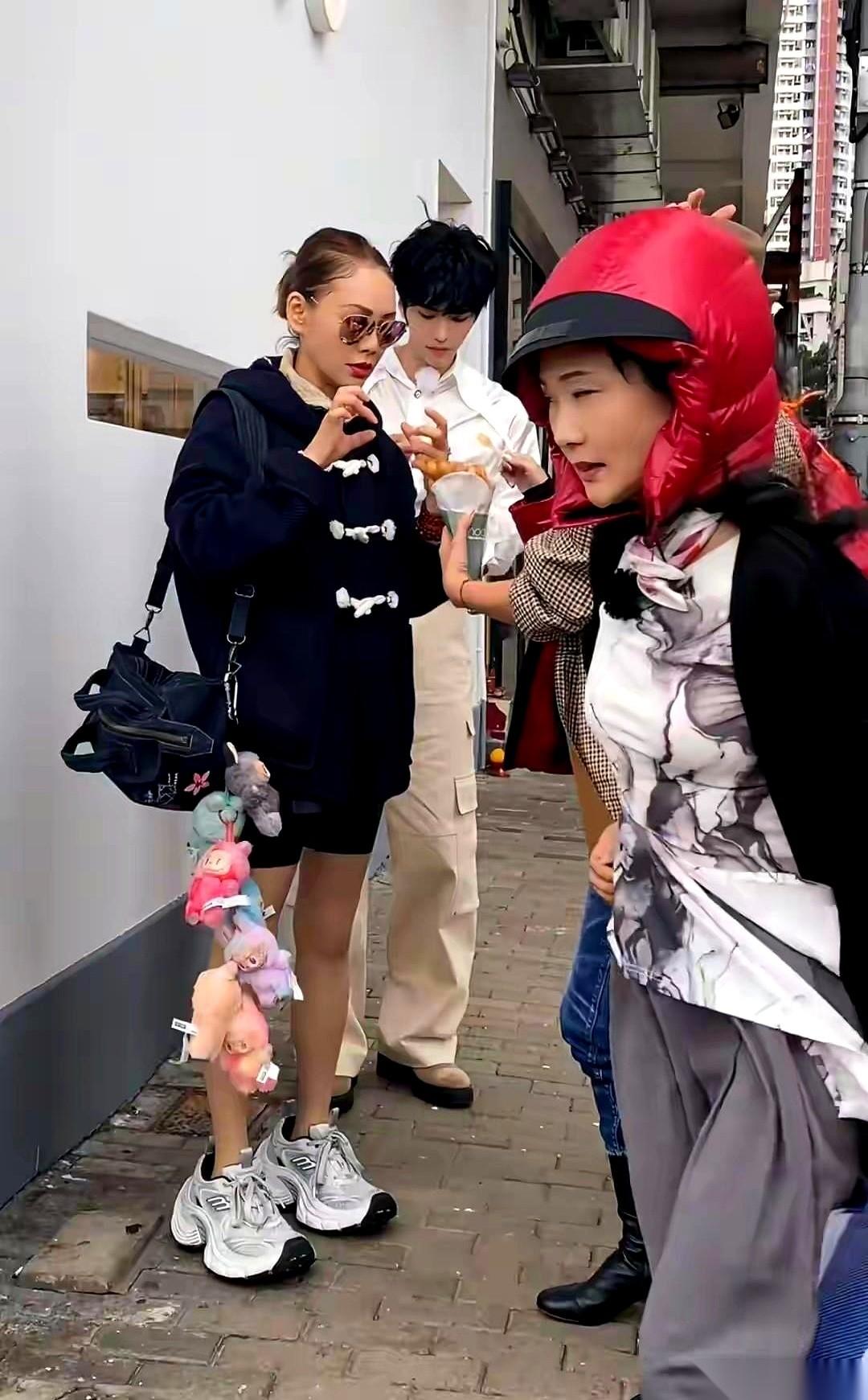 何赛飞那个羽绒服帽子，真是绝了。旁边宁静还在努力当“小姐姐”，包上挂满公仔，生