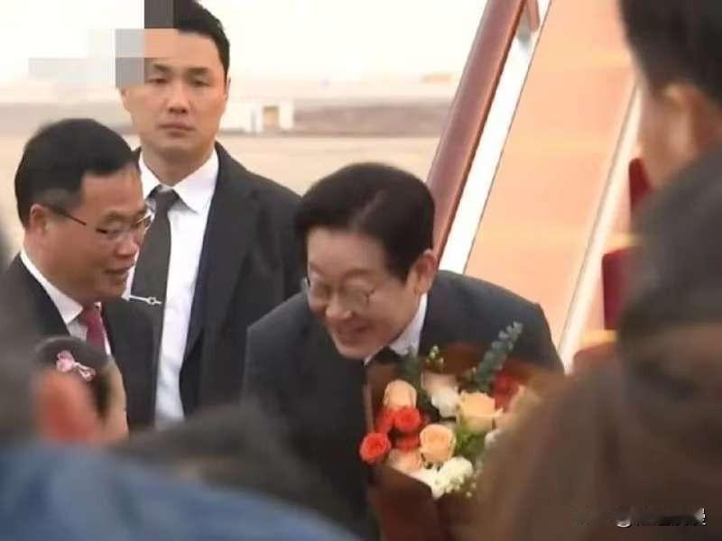 刚看到李在明夫妇在上海机场的照片，真的被暖到了。两个小朋友上去献花，他没有站在那