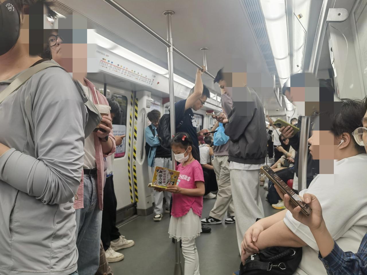 地铁里的这一幕，对比太鲜明，穿着粉红色衣服的站着小女孩和同样站着的成年人形成鲜明