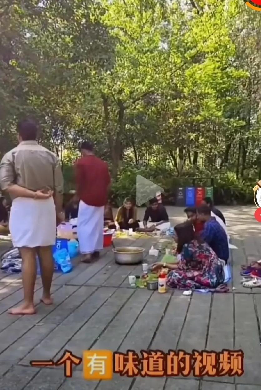 在成都南郊公园印度一团体游客在草坪上聚餐，后离去时大量垃圾散落一地。周围游