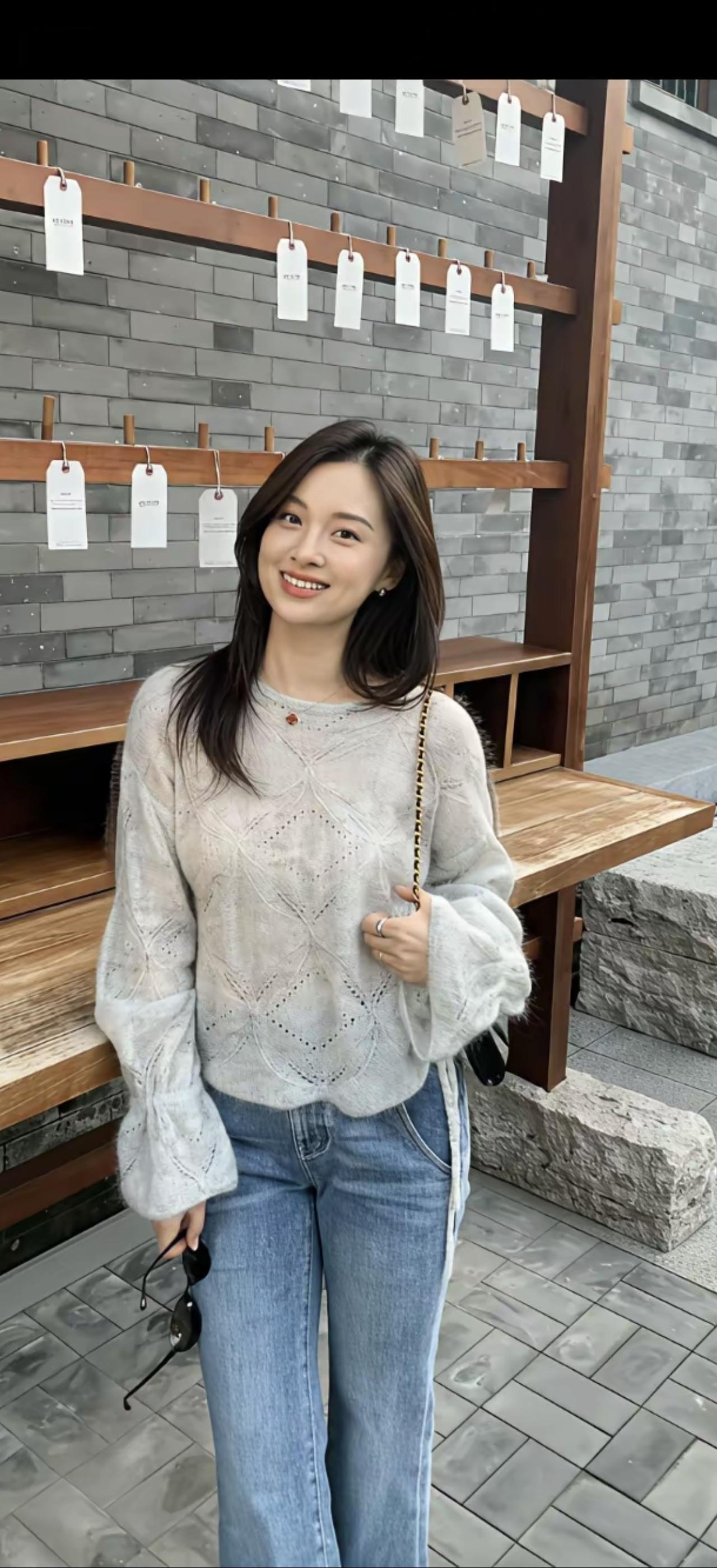 穿毛衣和牛仔裤的笑容女孩。
