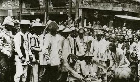 1855年，京城，小刀会一名女将被凌迟处死，她被五花大绑地捆在木桩上，表情极度痛