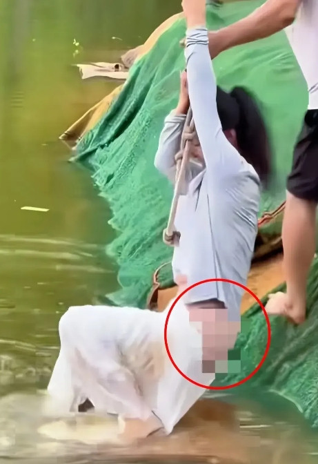 气愤！一女子外出游玩掉入河中，周围人不去施救，一男子下水将女子救上岸，由于女子全
