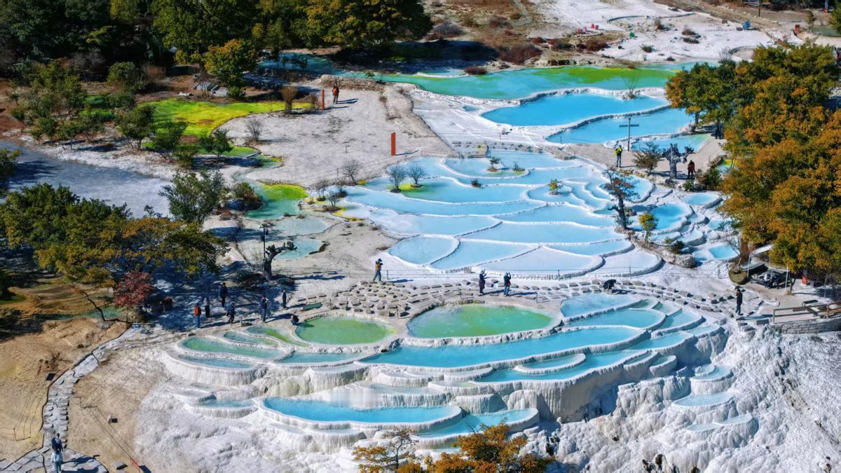 位于云南省香格里拉的白水台，在晴朗的天空下展现出其独特的魅力。作为中国最大的石灰