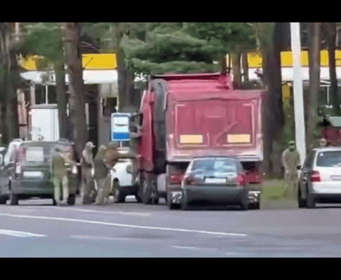 一群乌克兰征兵办（TCC）人员在路上堵住了一辆带拖挂的大卡车，其中一名TCC人员