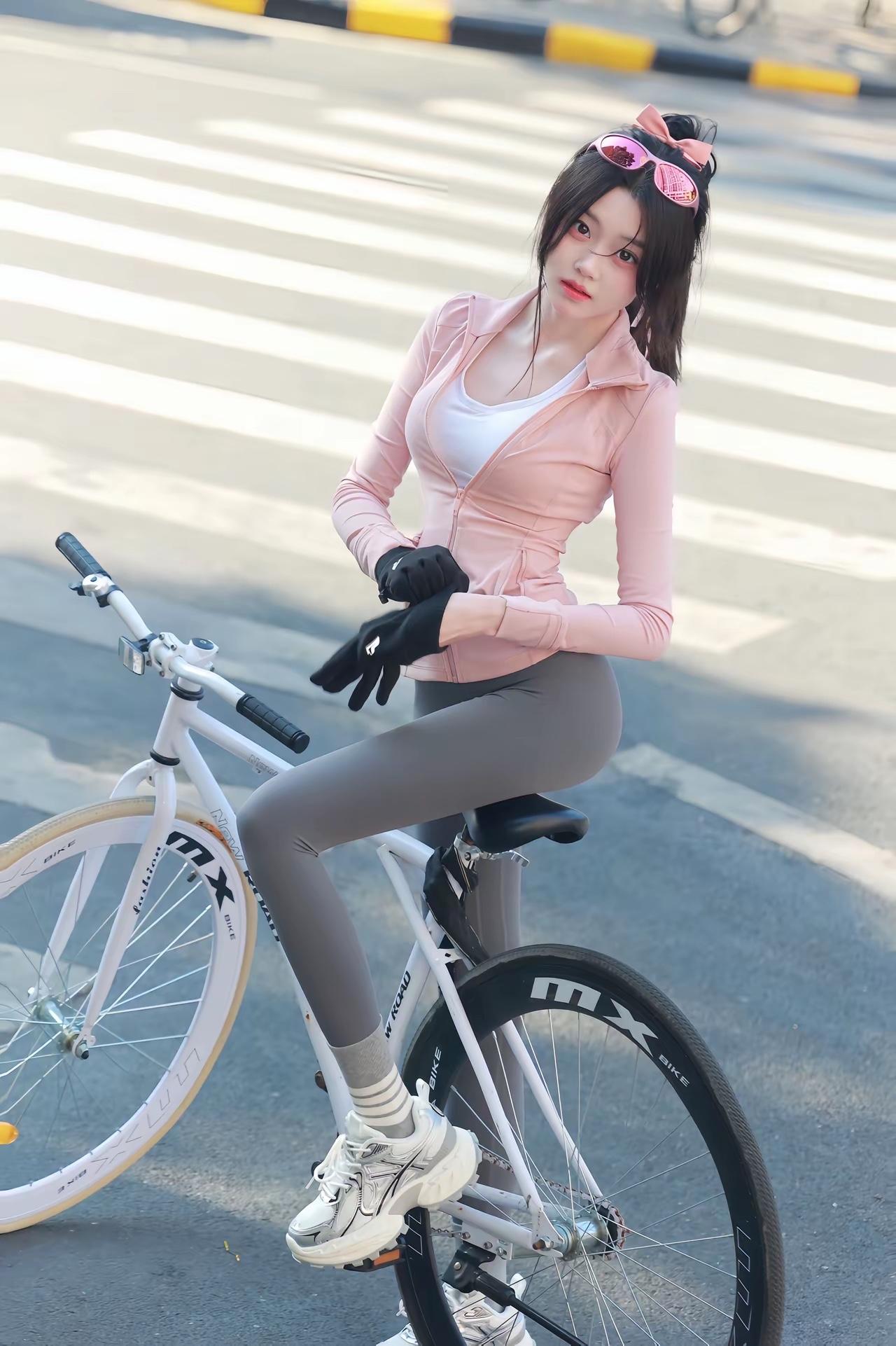 粉调骑行斑马线织成的琴键上粉色骑行服是跃动的音符墨镜滑在发梢蝴蝶结系住