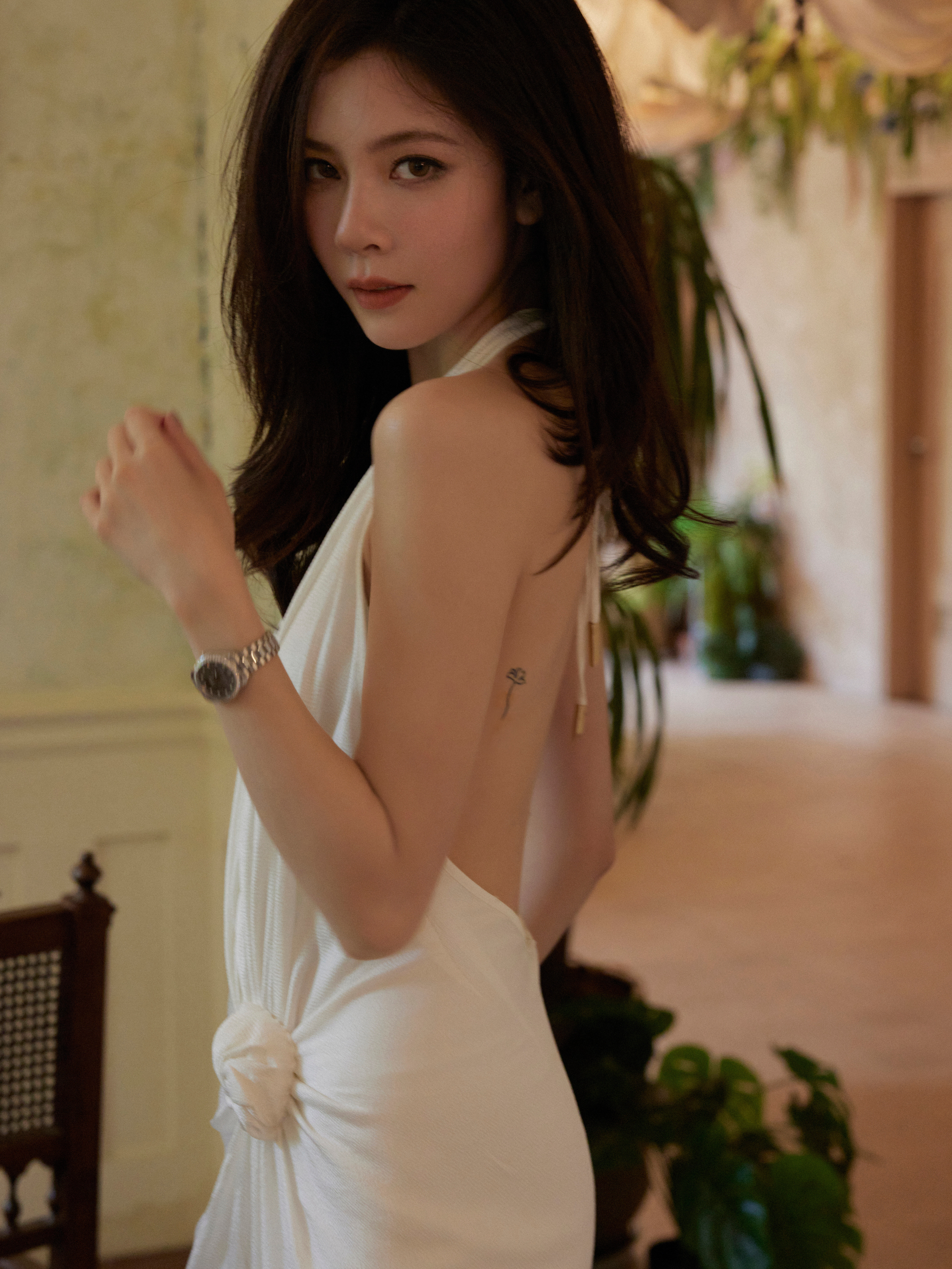 宋妍霏一袭白色挂脖缎面裙，简约剪裁勾勒优雅线条，挂脖设计露出精致肩颈，褶皱与花