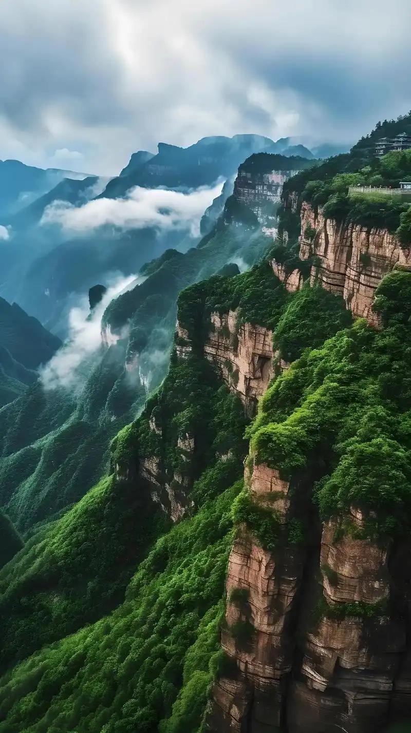 云雾漫卷太行山脉，丹崖绝壁刺破苍霭，层叠绿意攀附崖壁，山的雄奇与灵秀在此相融成诗