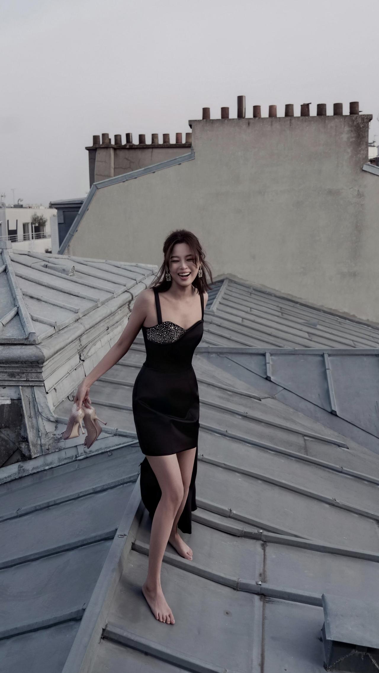 影后也俏皮，辛芷蕾一袭超短裙，赤脚爬上楼顶看风景。屋顶的风景很美人更美。