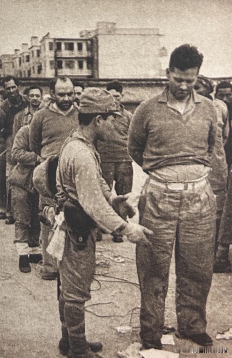 1940年12月，​香港沦陷后，​被俘的英军士兵在接受搜查，身高差太大了，真的是