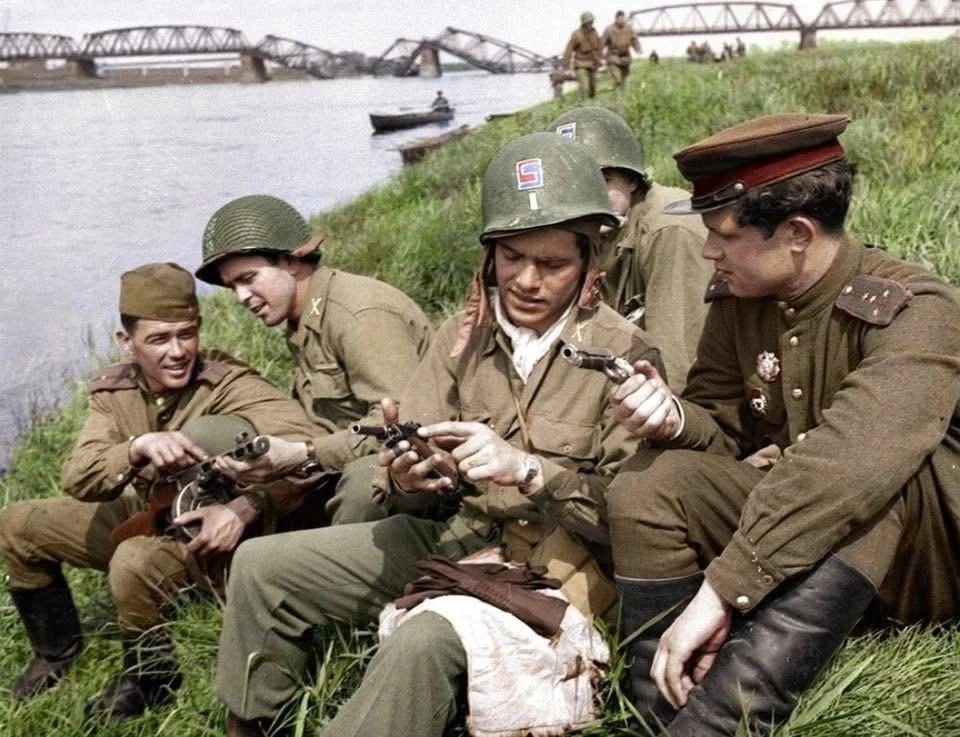 1945年4月，德国易北河会师后的苏美两军士兵正在相互介绍己方武器装备！苏军介