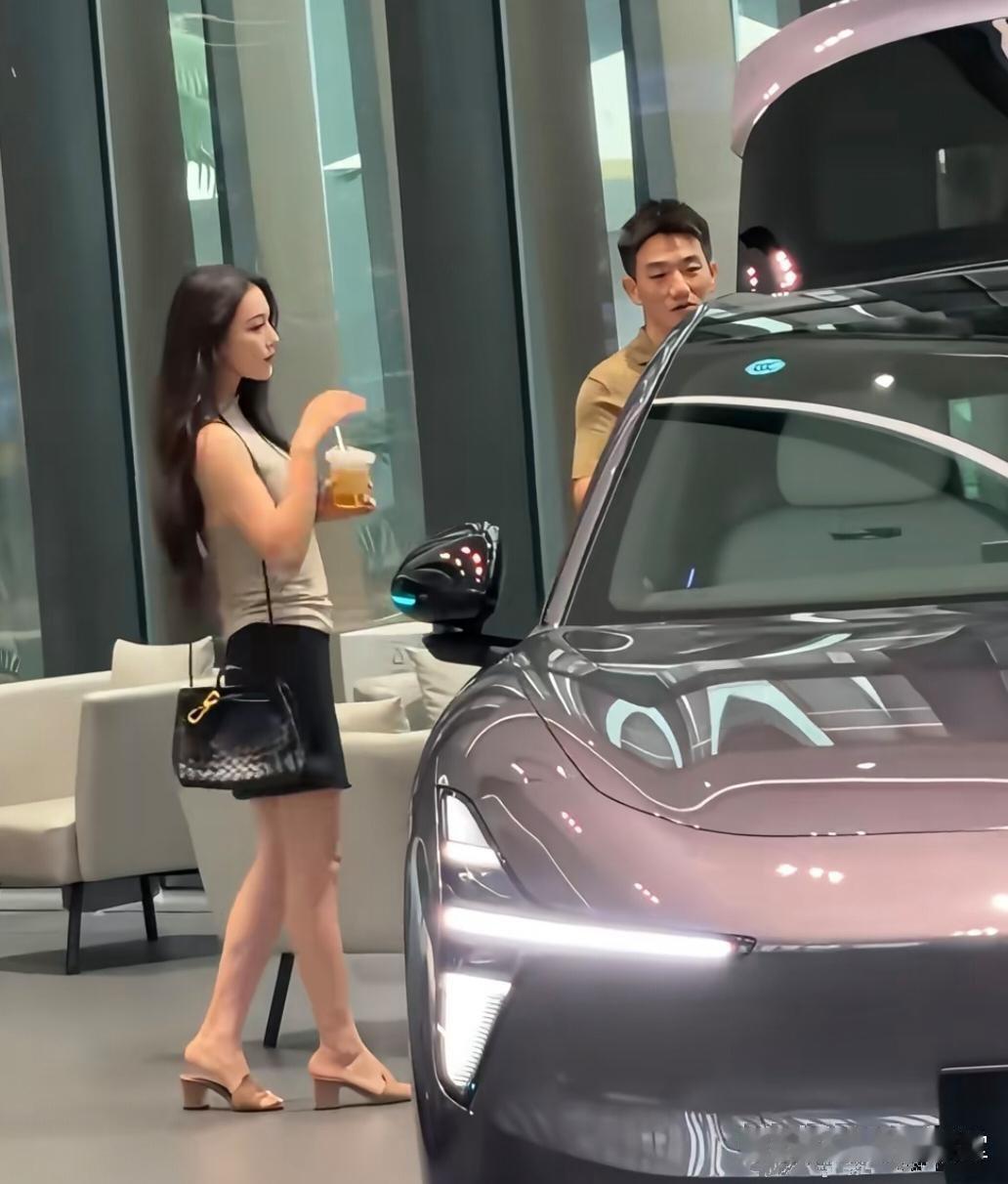 39岁张馨予和老公何捷现身广州一间车企看豪车，她背着4万元的名牌包，打扮时尚贵气