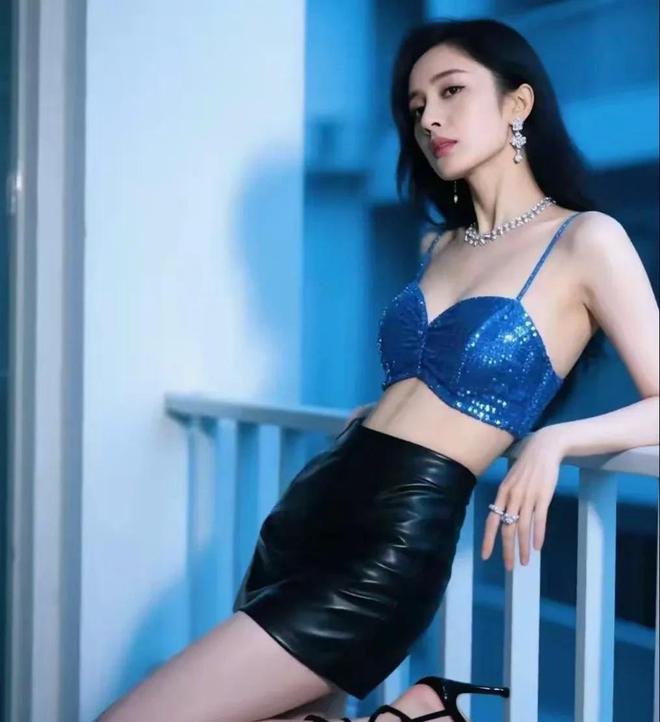 杨幂亮相时尚造型，湖蓝色吊带搭配黑色皮短裤，展现清凉火辣魅力。文章来源于网络，旨