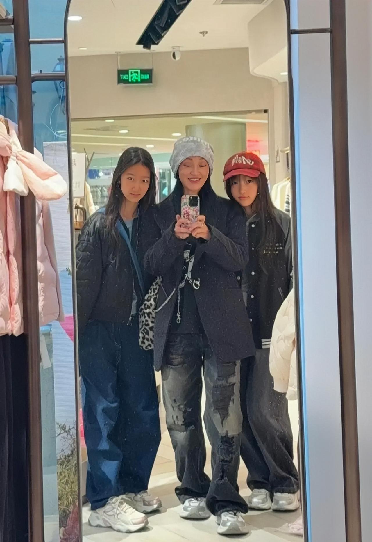 近日，赵子琪带着俩女儿逛商场，母女三人在服装区的画面。赵子琪对着镜子，与两个