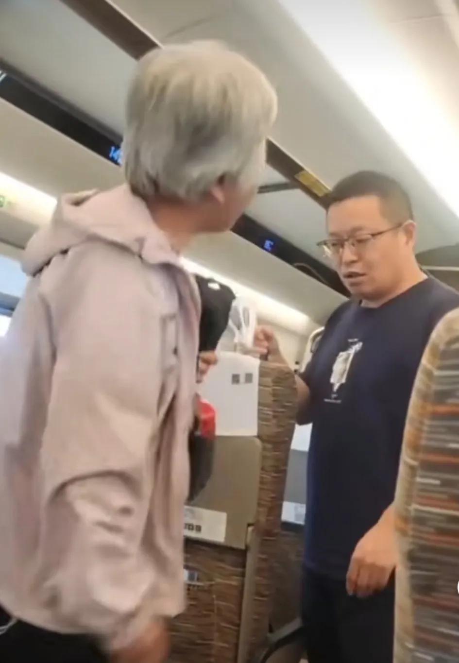 高铁上，男子站在过道上看自己闺女。座位上的大妈嫌弃他站在旁边，让他走开。男子说要