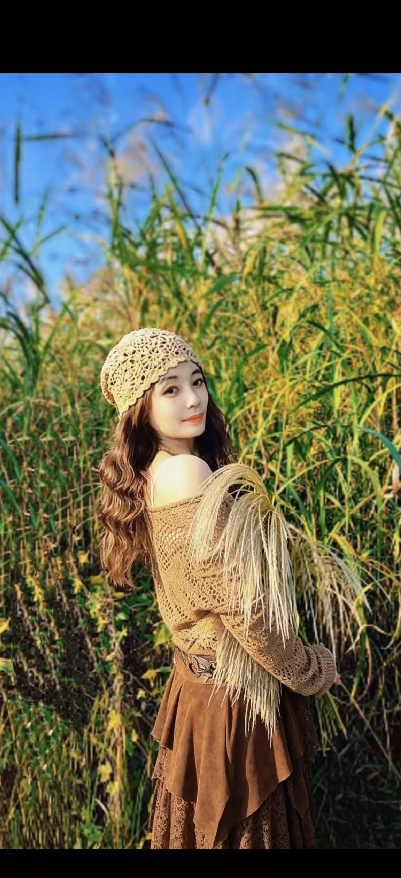 一个女孩在草地上摆姿势拍照。
