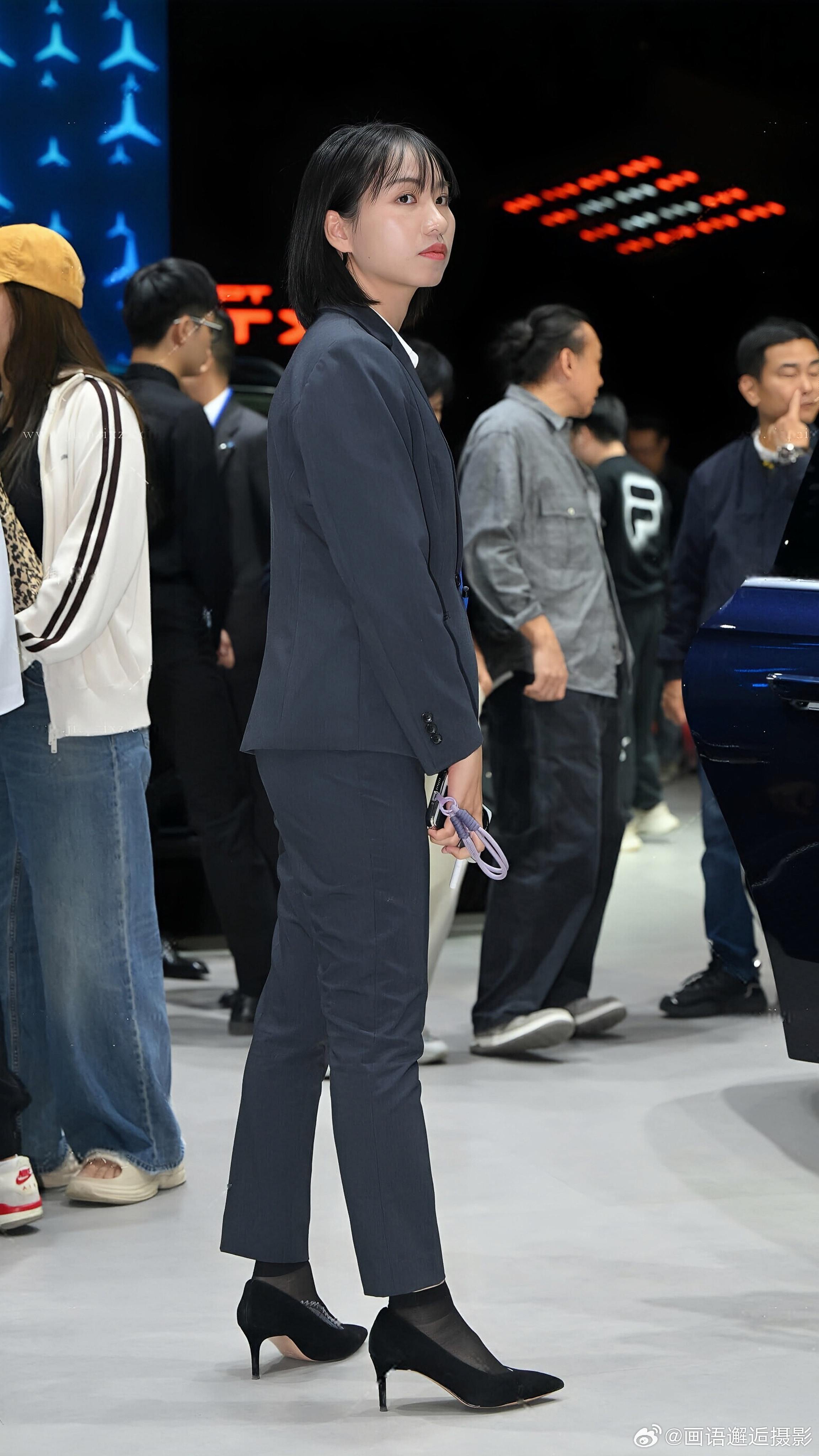 发现你的魅力藏青色西装套装内搭白衬衫，佩戴蓝色挂绳，搭配黑色高跟鞋与丝袜，尽显