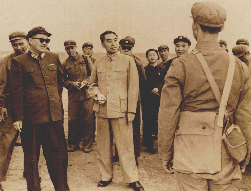 和参加大比武的战士们交谈。戴墨镜的是贺龙元帅，他当时主持军委的日常工作。右边是敬