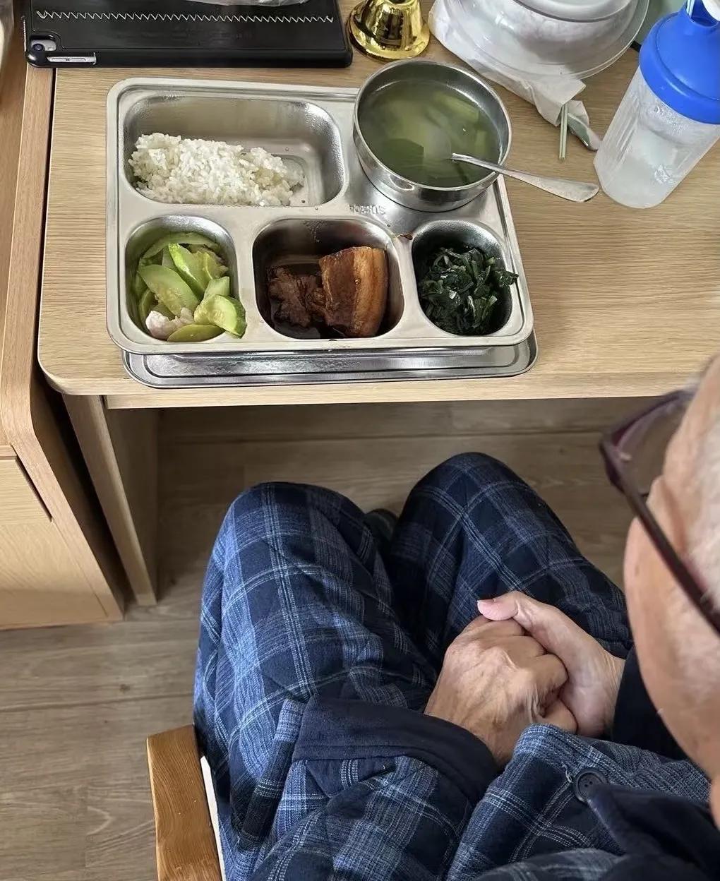 养老院里，老人穿着厚厚的家居服，手紧紧地攥着，孤独地享用午餐，餐盘里两个素菜，一