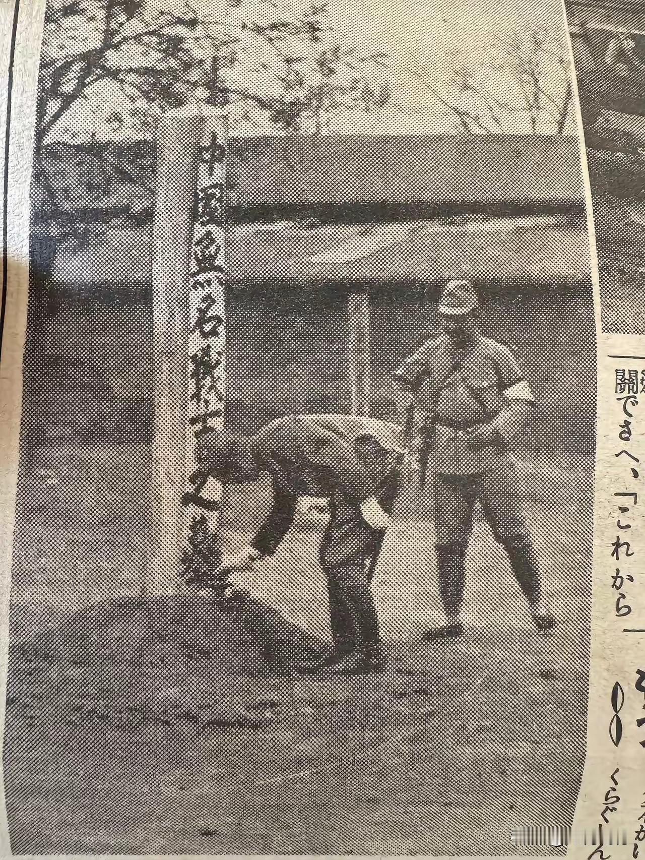 两个日本鬼子，在一个矮小坟头前拍下了这张照片，坟头前好像是立着一块木头，上面写着