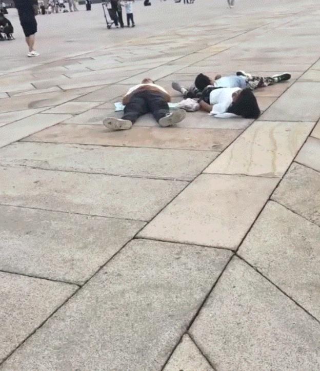 一家人前往天安门排队等看升国旗，不料正在进行升旗仪式时，一家人却犯困直接躺广场上