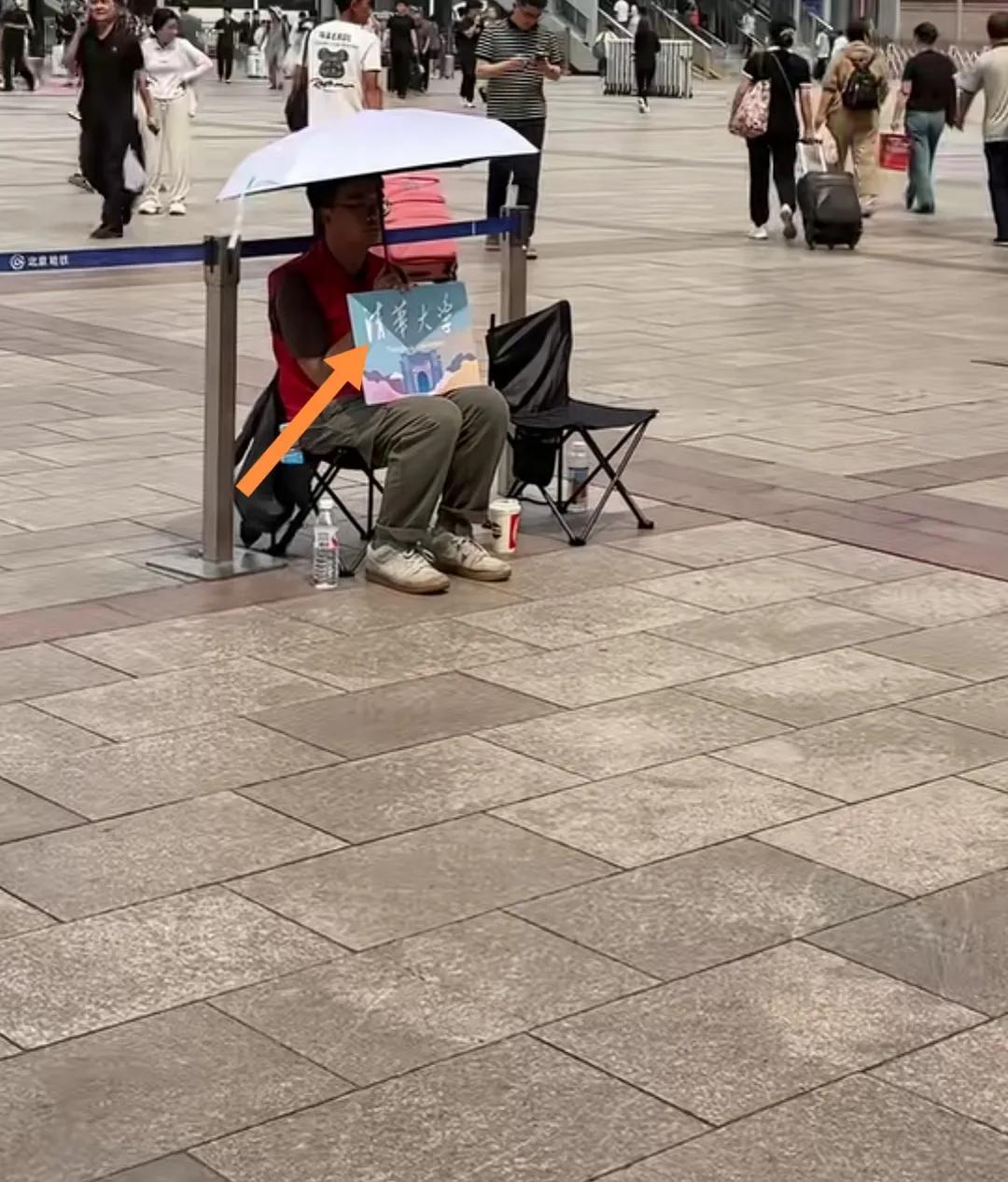 清华大学学长车站一个人打伞接新生。