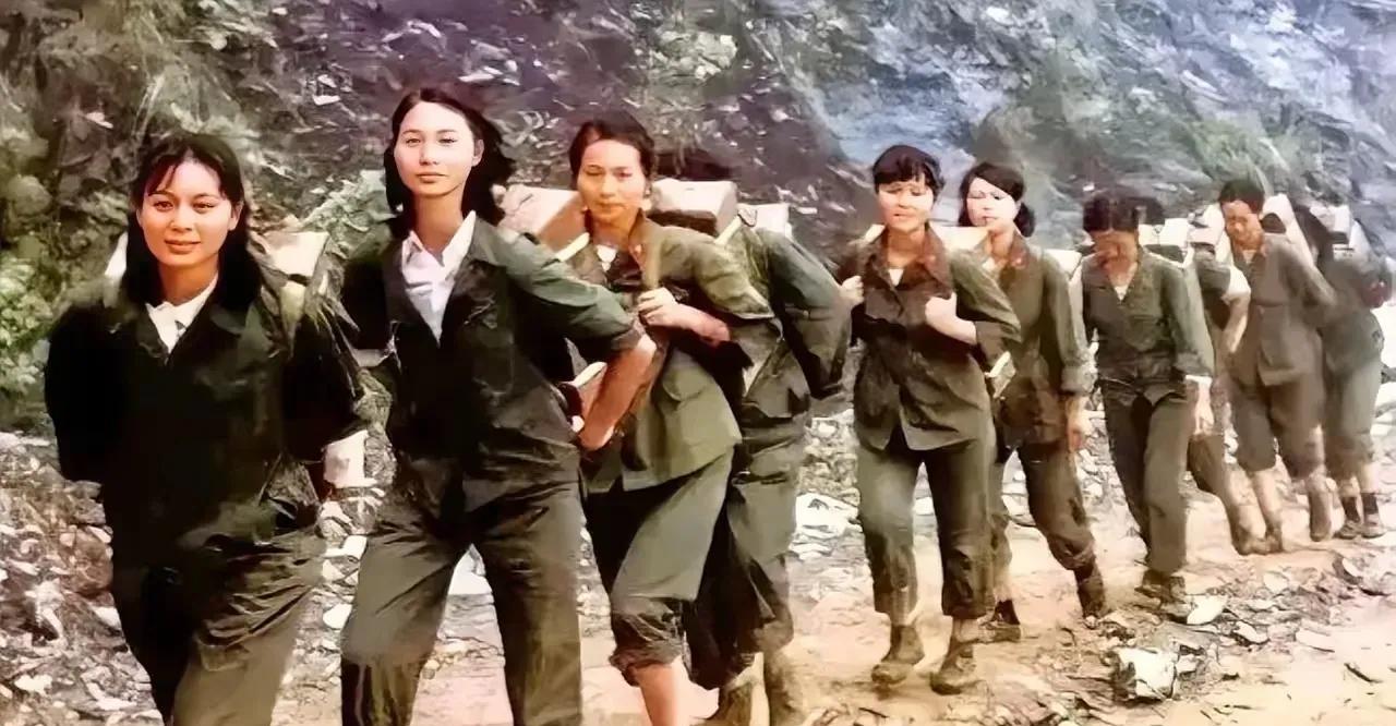 1986年，老山前线的泥泞山道上，一群女兵踩着胶鞋艰难跋涉。军绿色的鞋帮沾满泥
